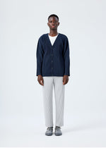 A model wears the HOMME PLISSÉ ISSEY MIYAKE BASICS basics-cardigan-light-grey-fw26.