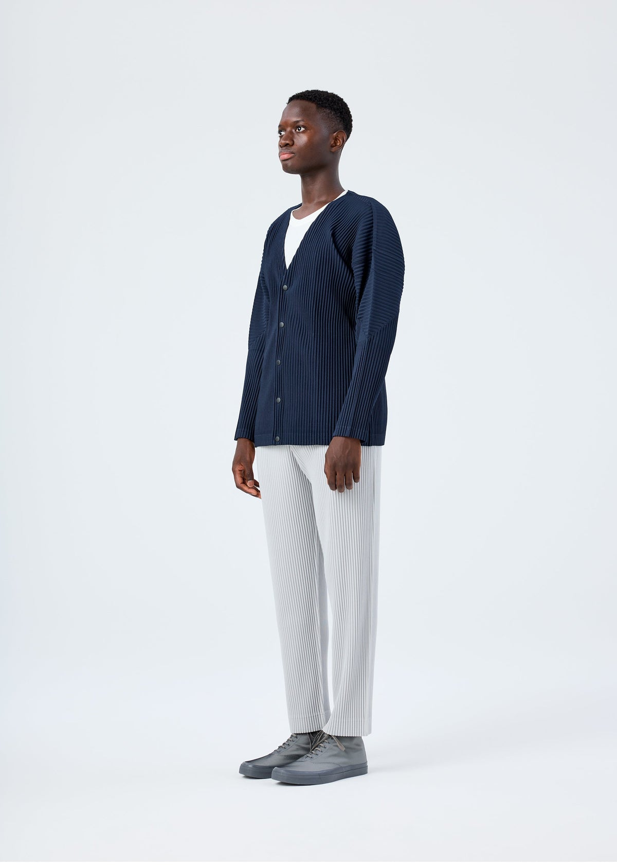 A model wears the HOMME PLISSÉ ISSEY MIYAKE BASICS basics-cardigan-navy-2.