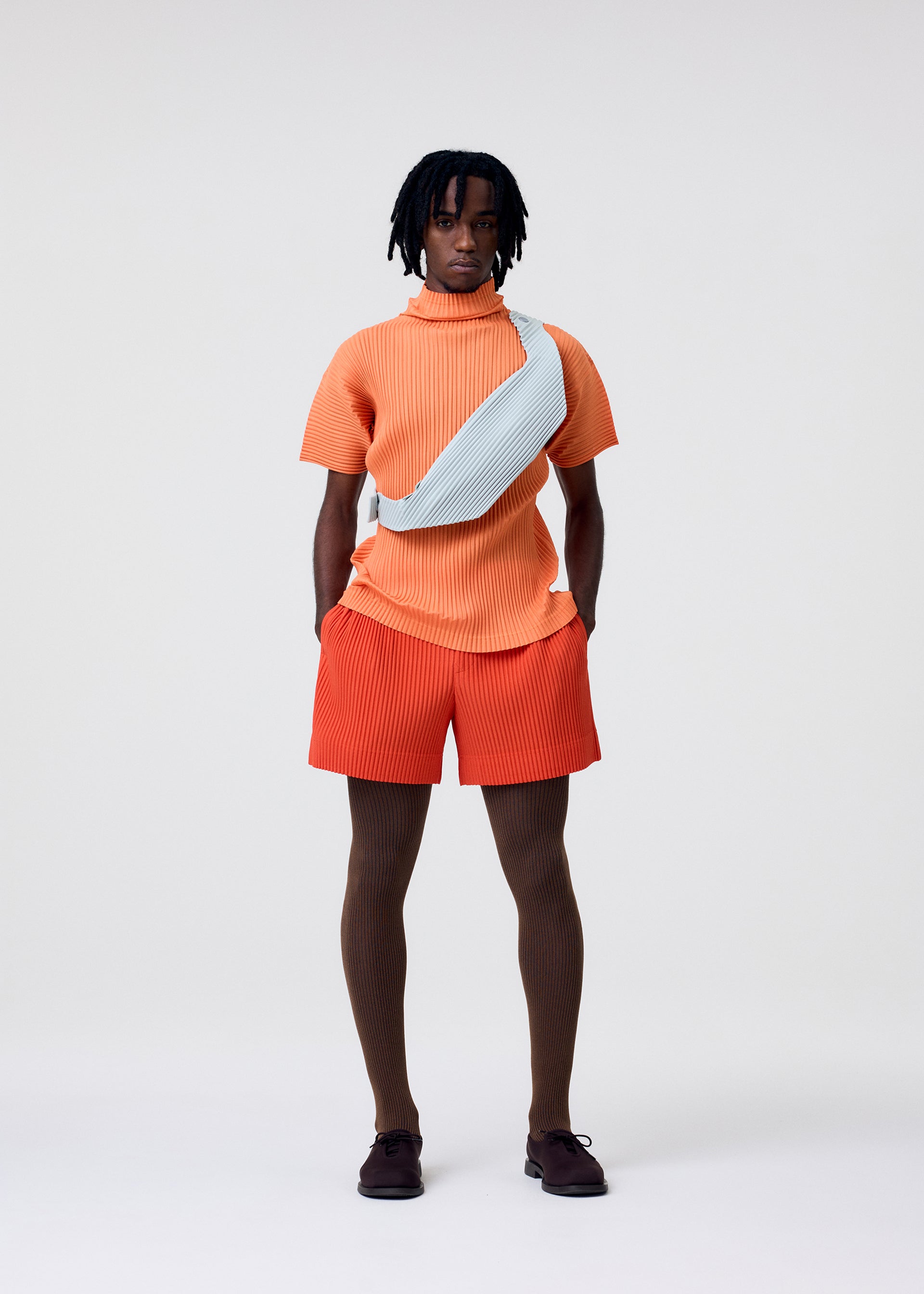 A model wears the Homme Plisse Issey Miyake VERSATILE CROSSBODY bag.