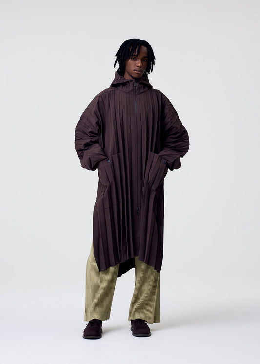 A model wears the HOMME PLISSE ISSEY MIYAKE EDGE COAT LIGHT prêt à porter.