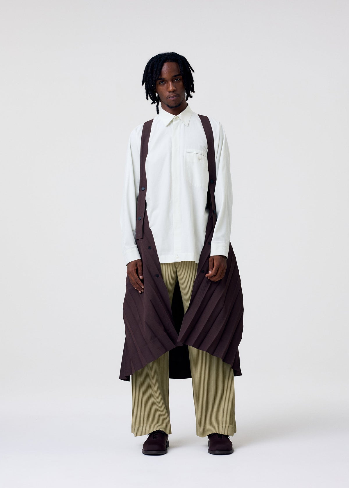 A model wears the HOMME PLISSE ISSEY MIYAKE EDGE COAT LIGHT prêt à porter.