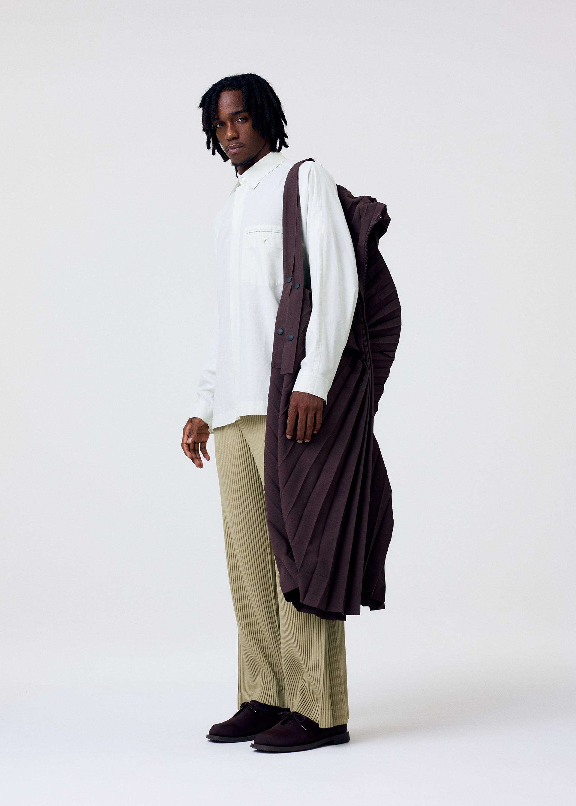 A model wears the HOMME PLISSE ISSEY MIYAKE EDGE COAT LIGHT prêt à porter.