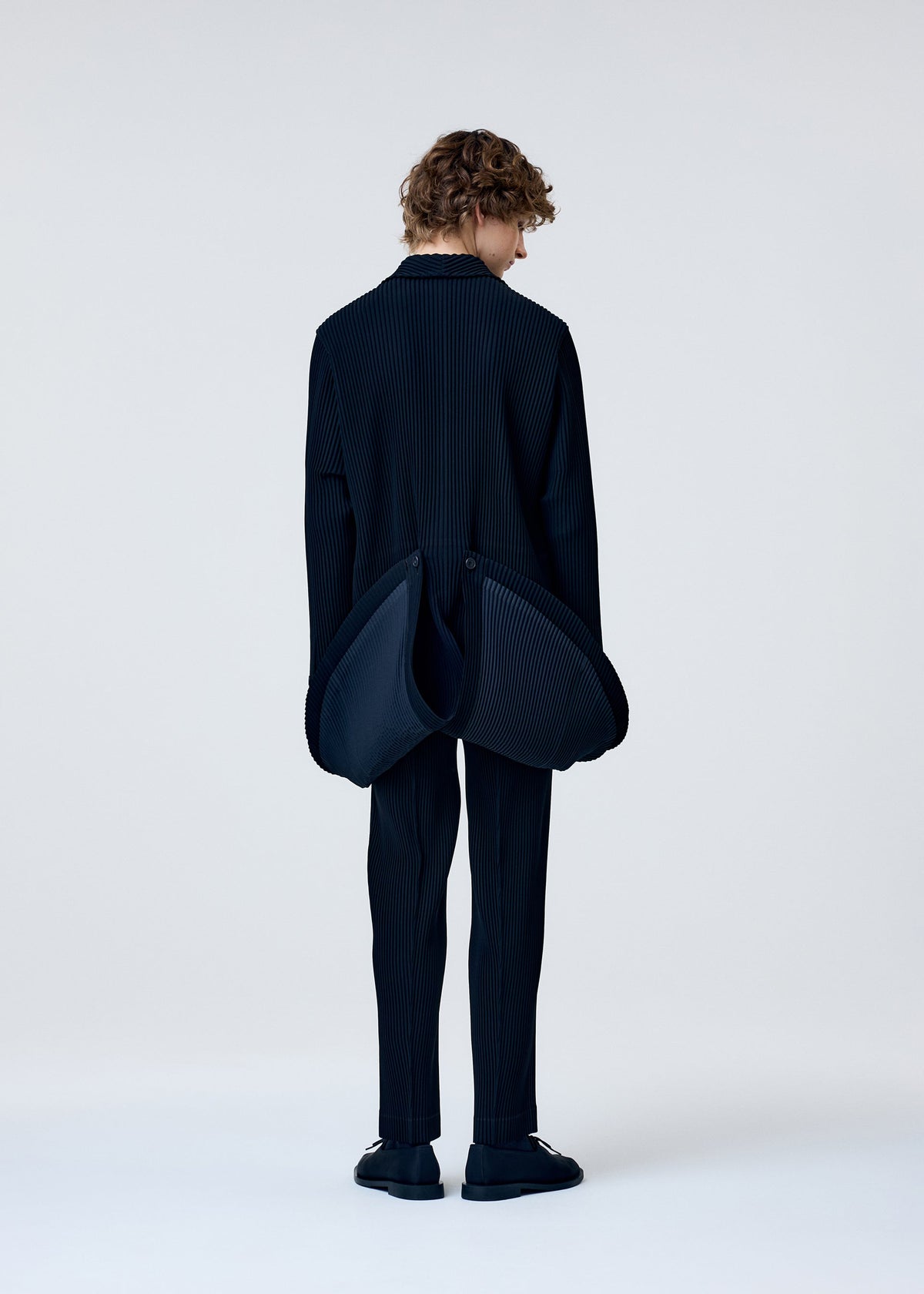 A model wears the Homme Plisse Issey Miyake TUXEDO PLEATS prêt à porter.