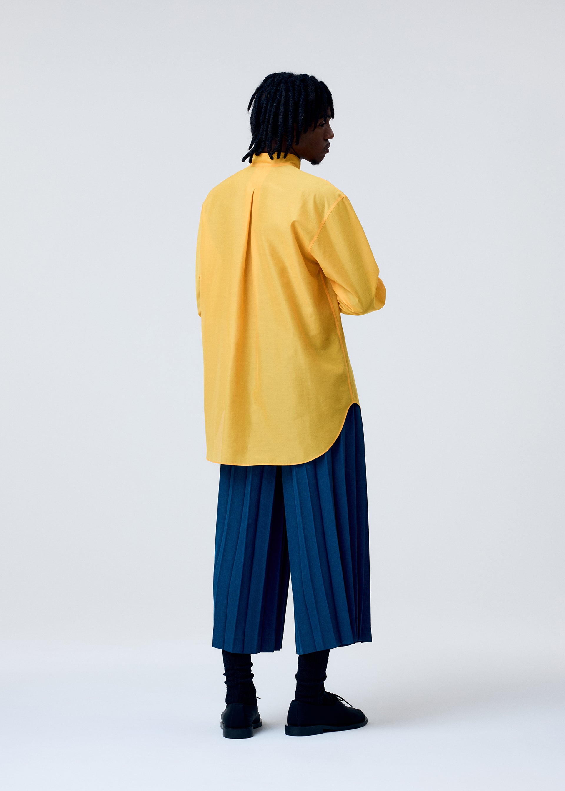 A model wears the HOMME PLISSE ISSEY MIYAKE EDGE ENSEMBLE prêt à porter.