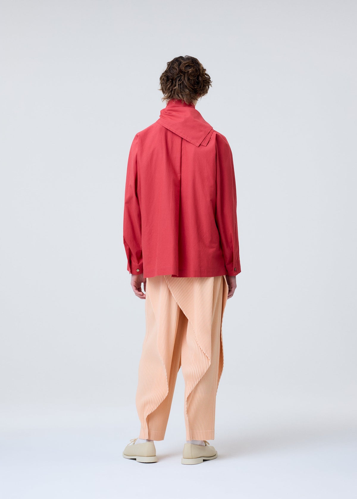 A model wears the HOMME PLISSE ISSEY MIYAKE STREAMLINE SHIRT prêt à porter.