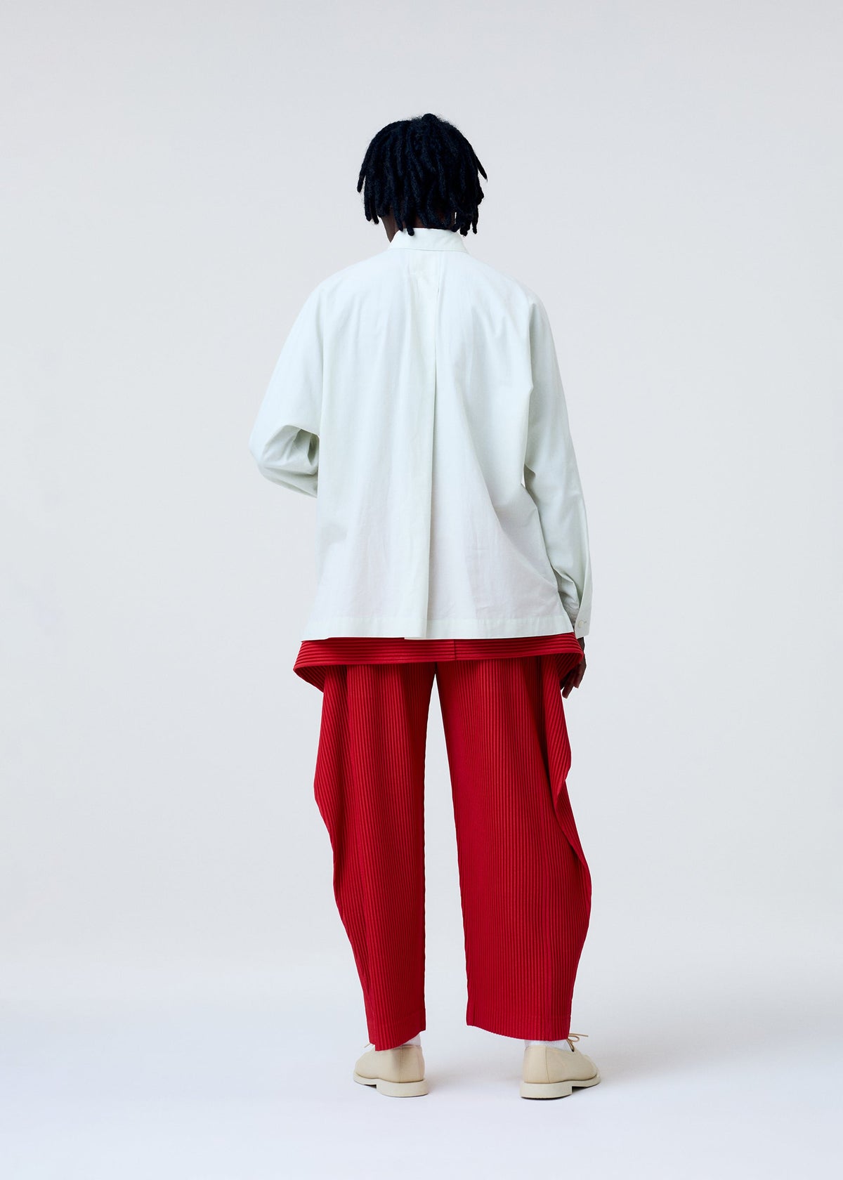 A model wears the HOMME PLISSE ISSEY MIYAKE STREAMLINE SHIRT prêt à porter.