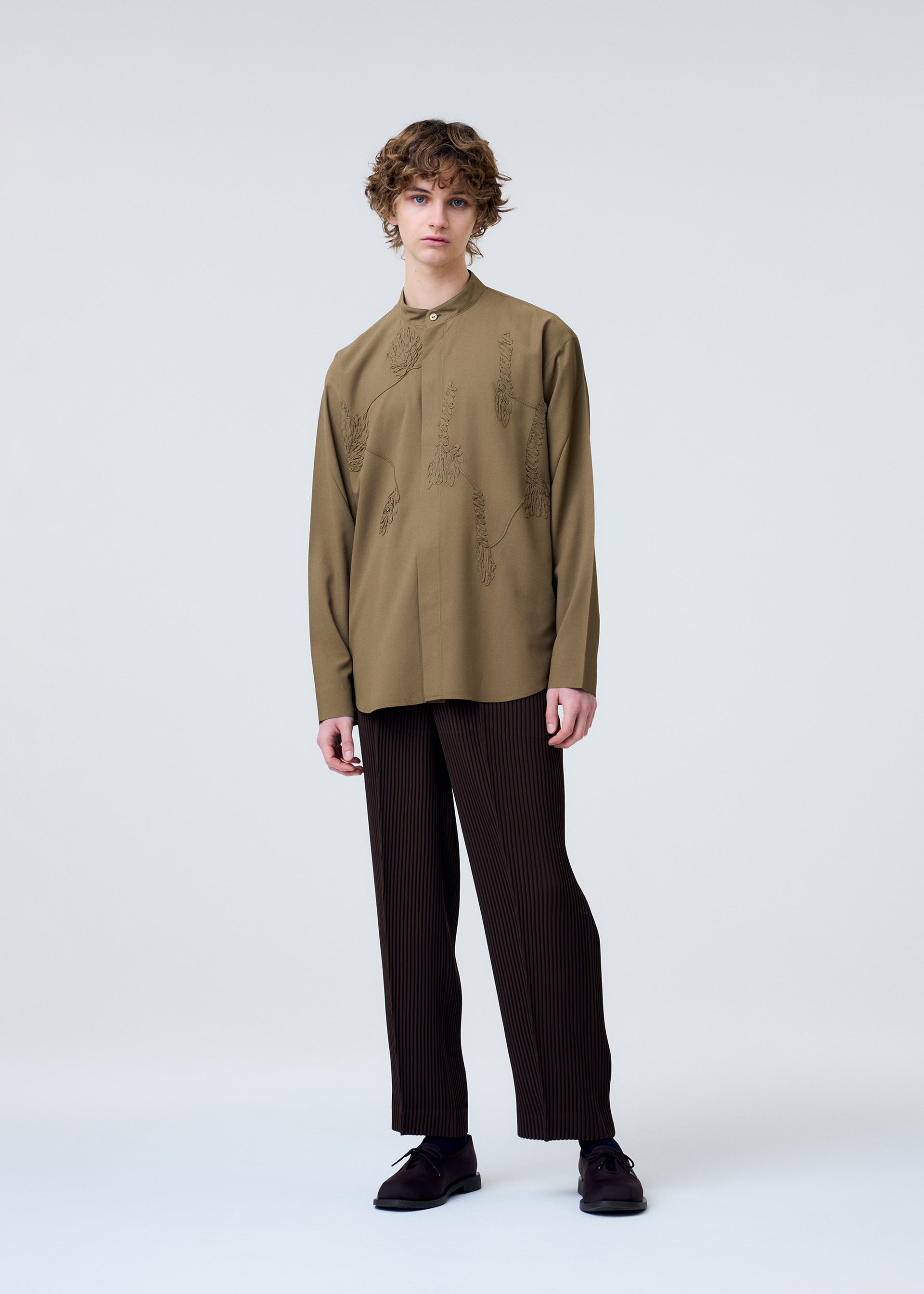 A model wears the Homme Plisse Issey Miyake EMBROIDERY PRESS SHIRT prêt à porter.