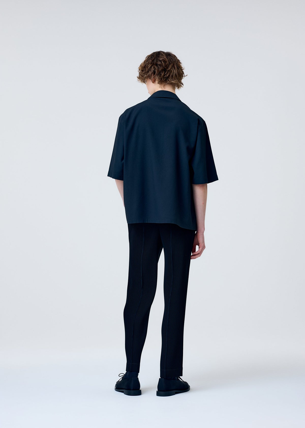 A model wears the Homme Plisse Issey Miyake EMBROIDERY PRESS SHIRT prêt à porter.