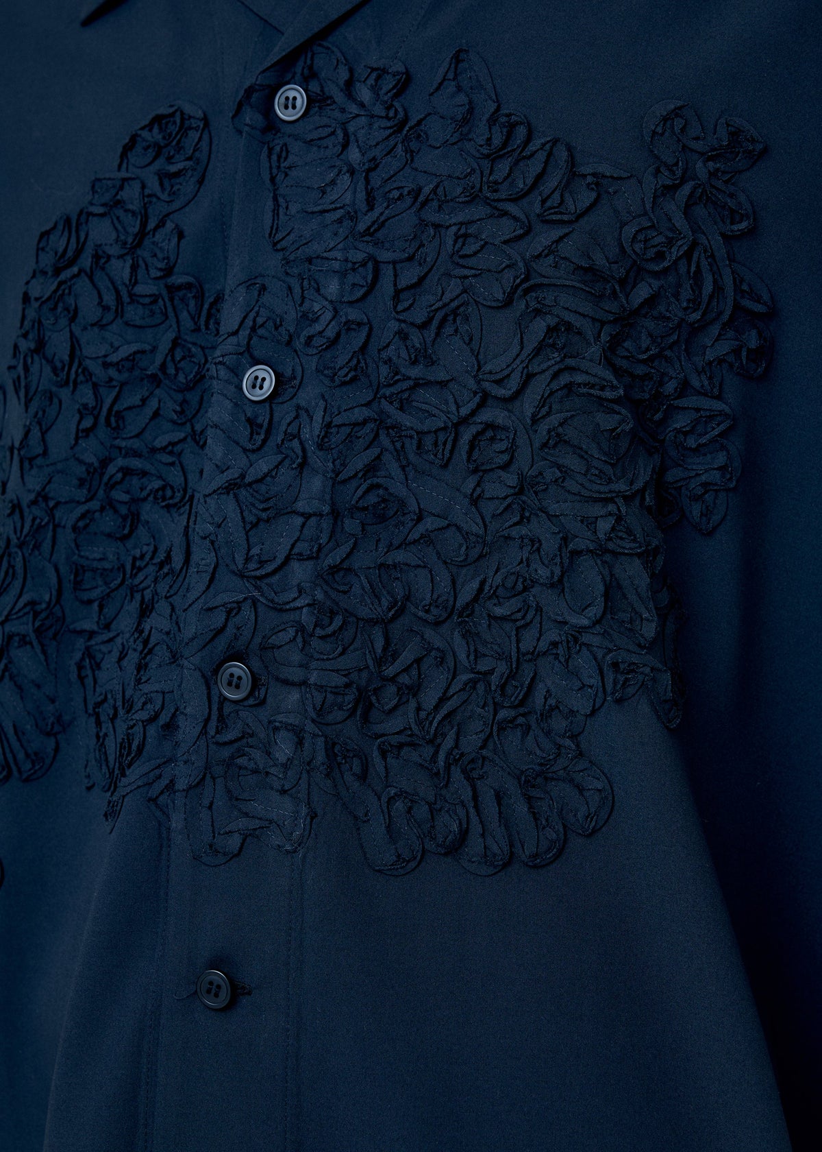 A model wears the Homme Plisse Issey Miyake EMBROIDERY PRESS SHIRT prêt à porter.