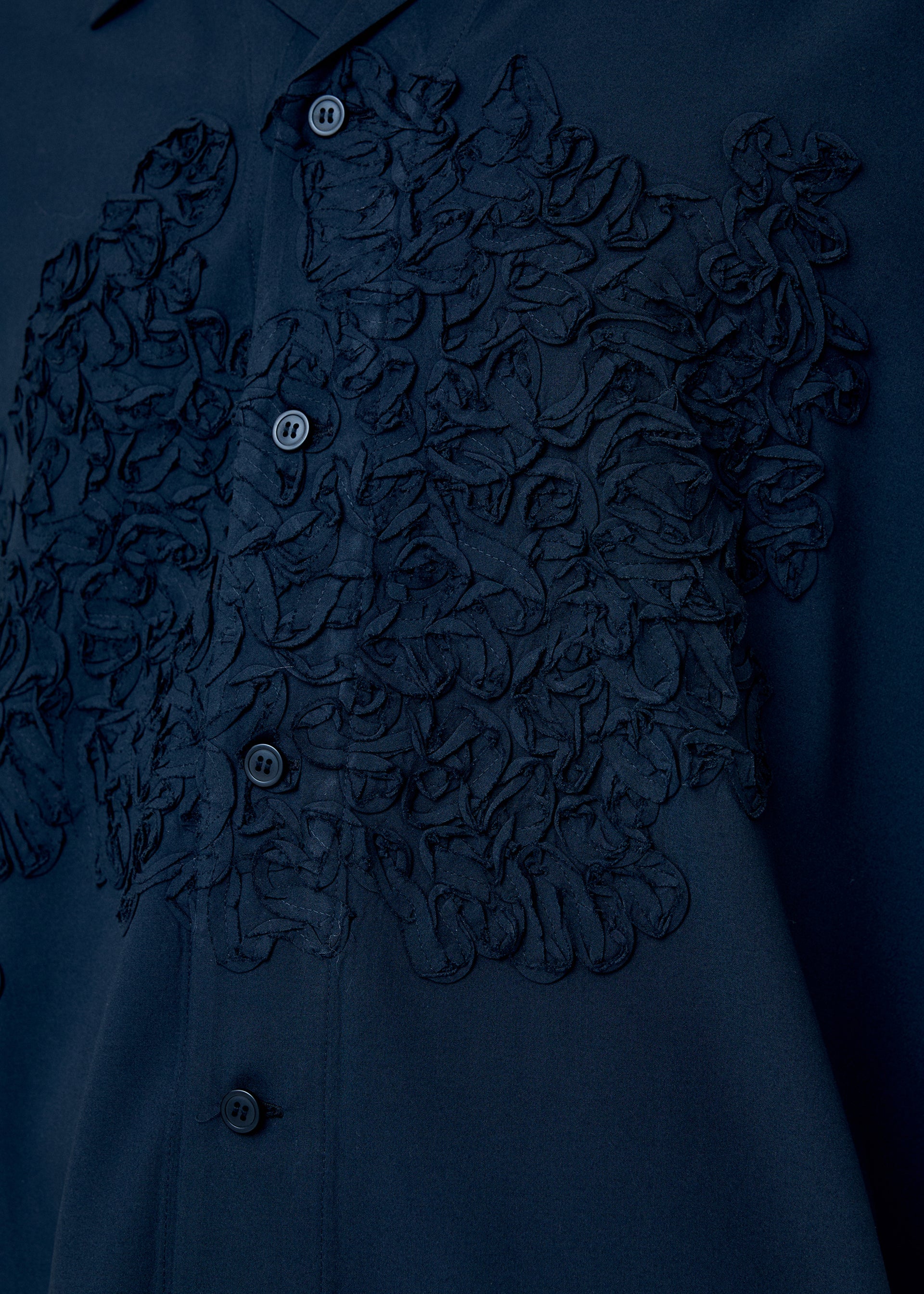 A model wears the Homme Plisse Issey Miyake EMBROIDERY PRESS SHIRT prêt à porter.