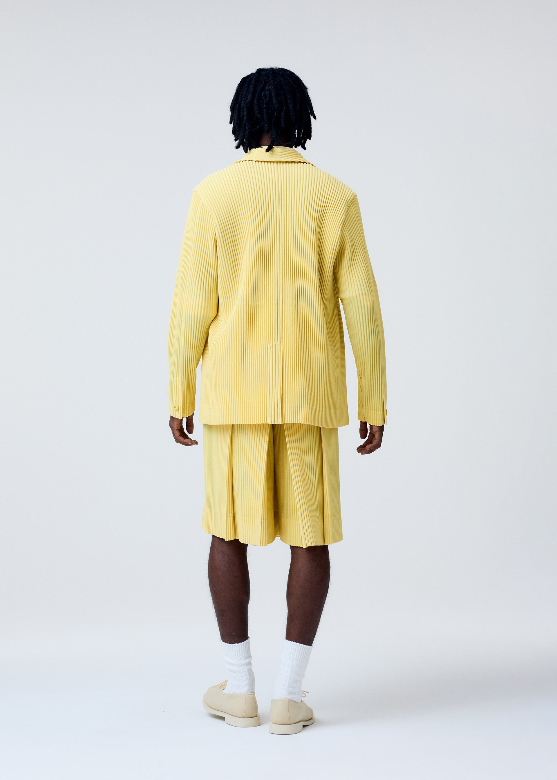 A model wears the Homme Plisse Issey Miyake TAILORED PLEATS 2 jacket.