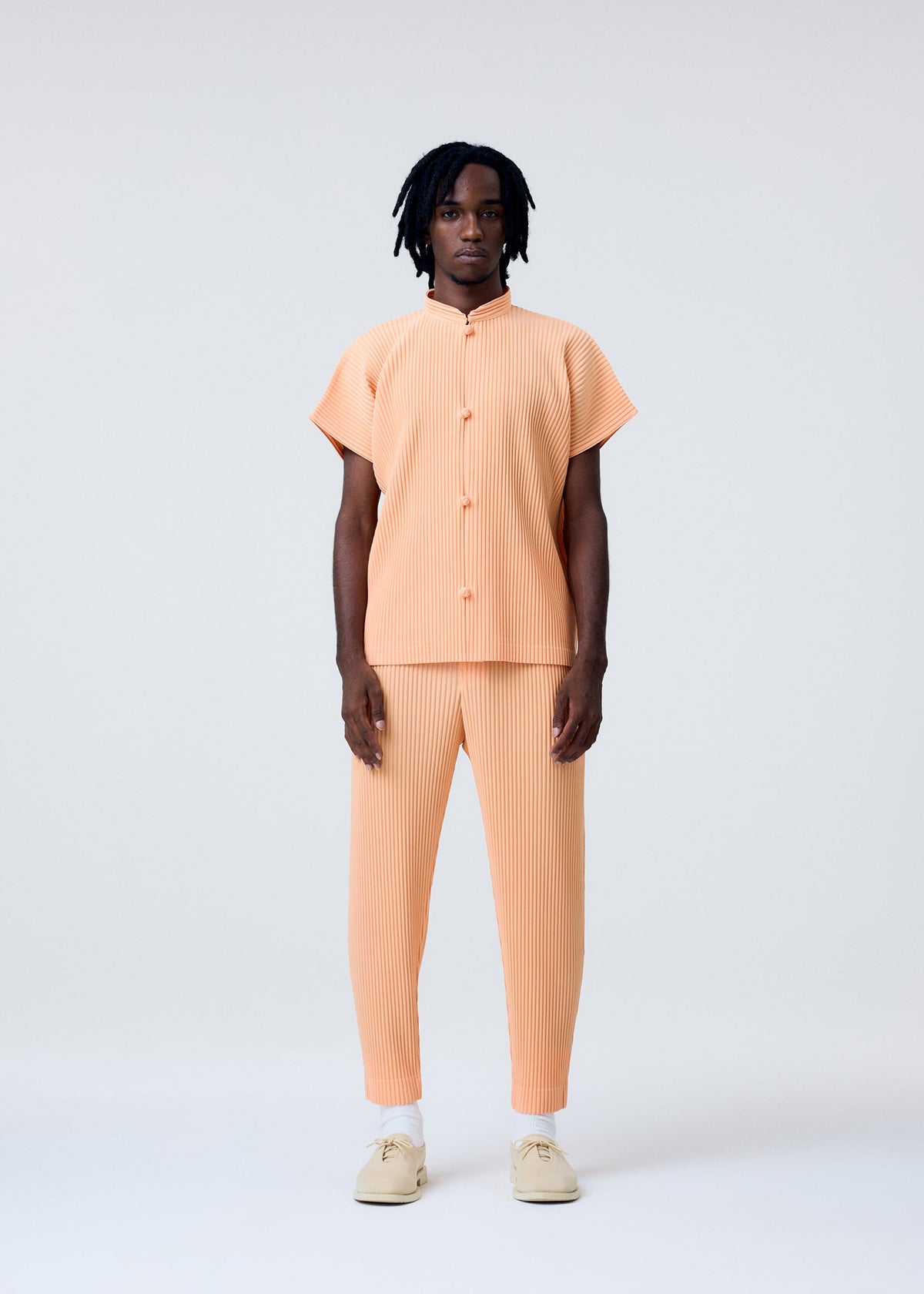 A model wears the Homme Plisse Issey Miyake MONTHLY COLORS   APRIL pants.