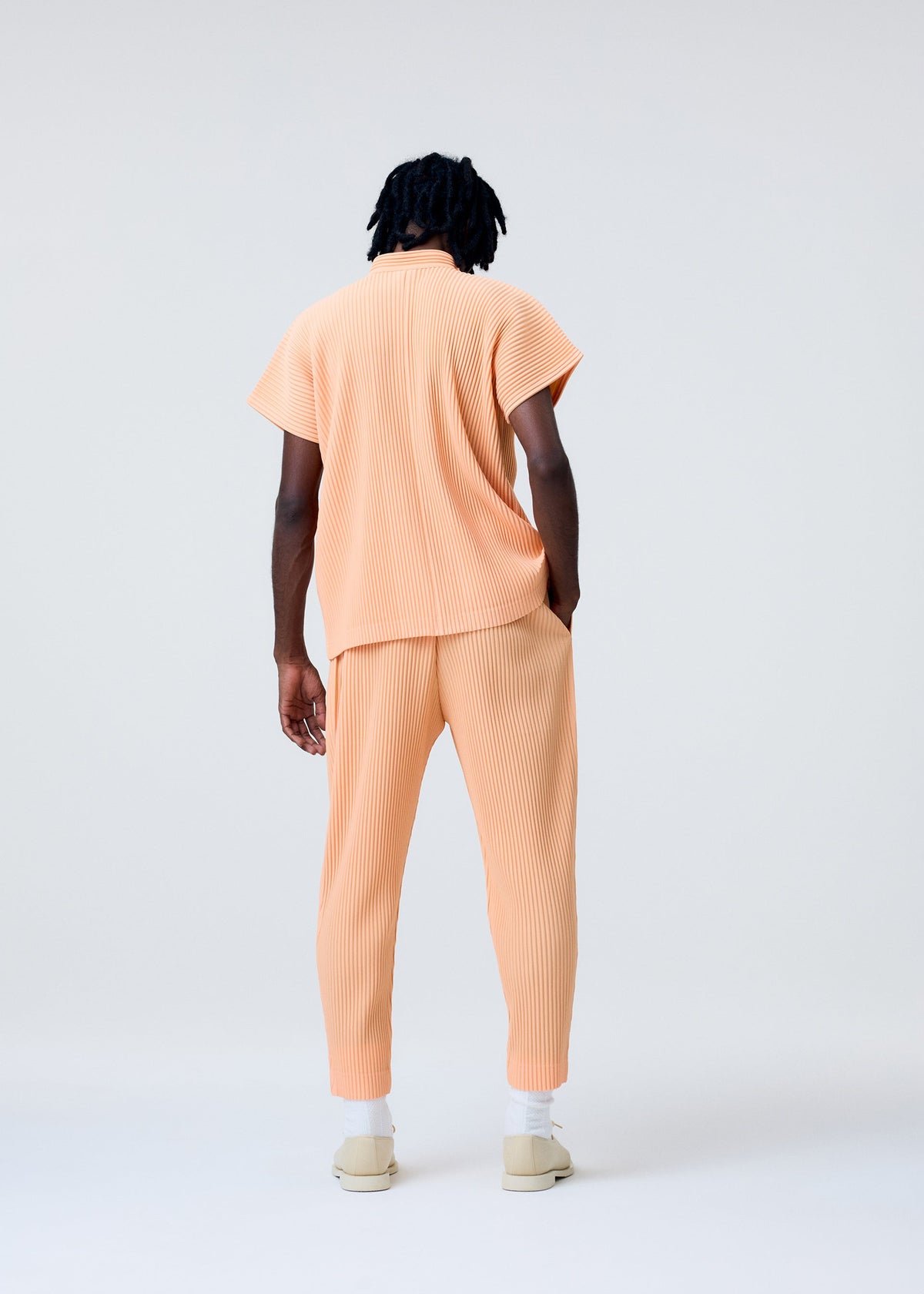 A model wears the Homme Plisse Issey Miyake MONTHLY COLORS   APRIL pants.