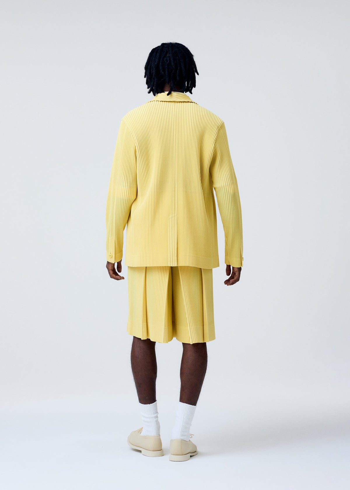 A model wears the Homme Plisse Issey Miyake TAILORED PLEATS 2 pants.