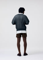A model wears the HOMME PLISSÉ ISSEY MIYAKE TAILORED PLEATS 3 tailored-pleats-3-trousers-genova-metal-ochre-1.