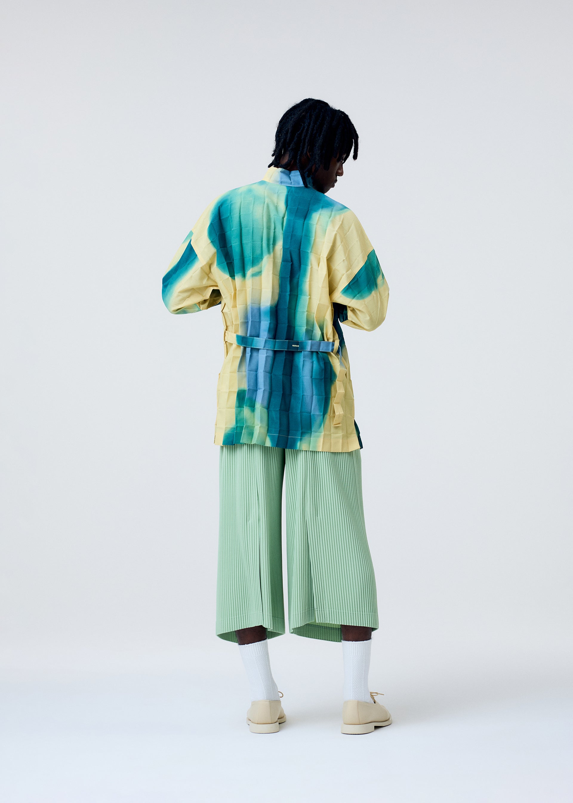 A model wears the Homme Plisse Issey Miyake PLEATS BOTTOMS 2 pants.