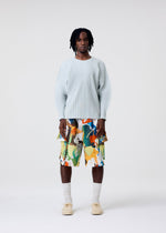 A model wears the HOMME PLISSÉ ISSEY MIYAKE PALETTE MARBLED palette-marbled-trousers-multicolor-1.