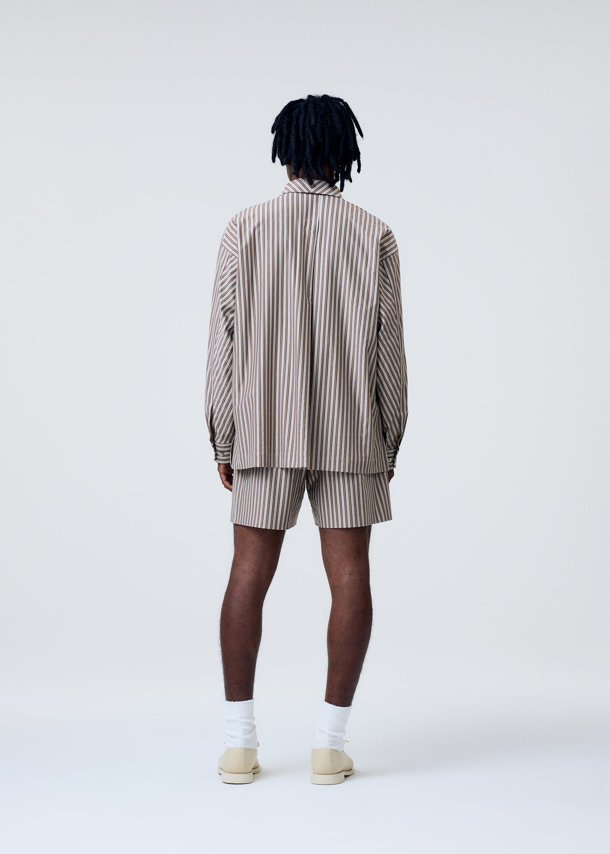 A model wears the Homme Plisse Issey Miyake STRIPE JERSEY shirt.