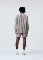 A model wears the Homme Plisse Issey Miyake STRIPE JERSEY shirt.