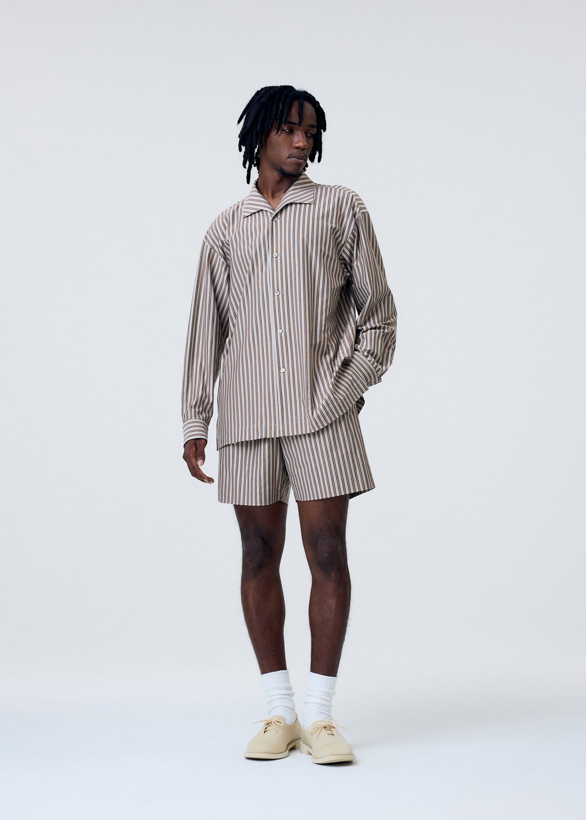 A model wears the Homme Plisse Issey Miyake STRIPE JERSEY shirt.