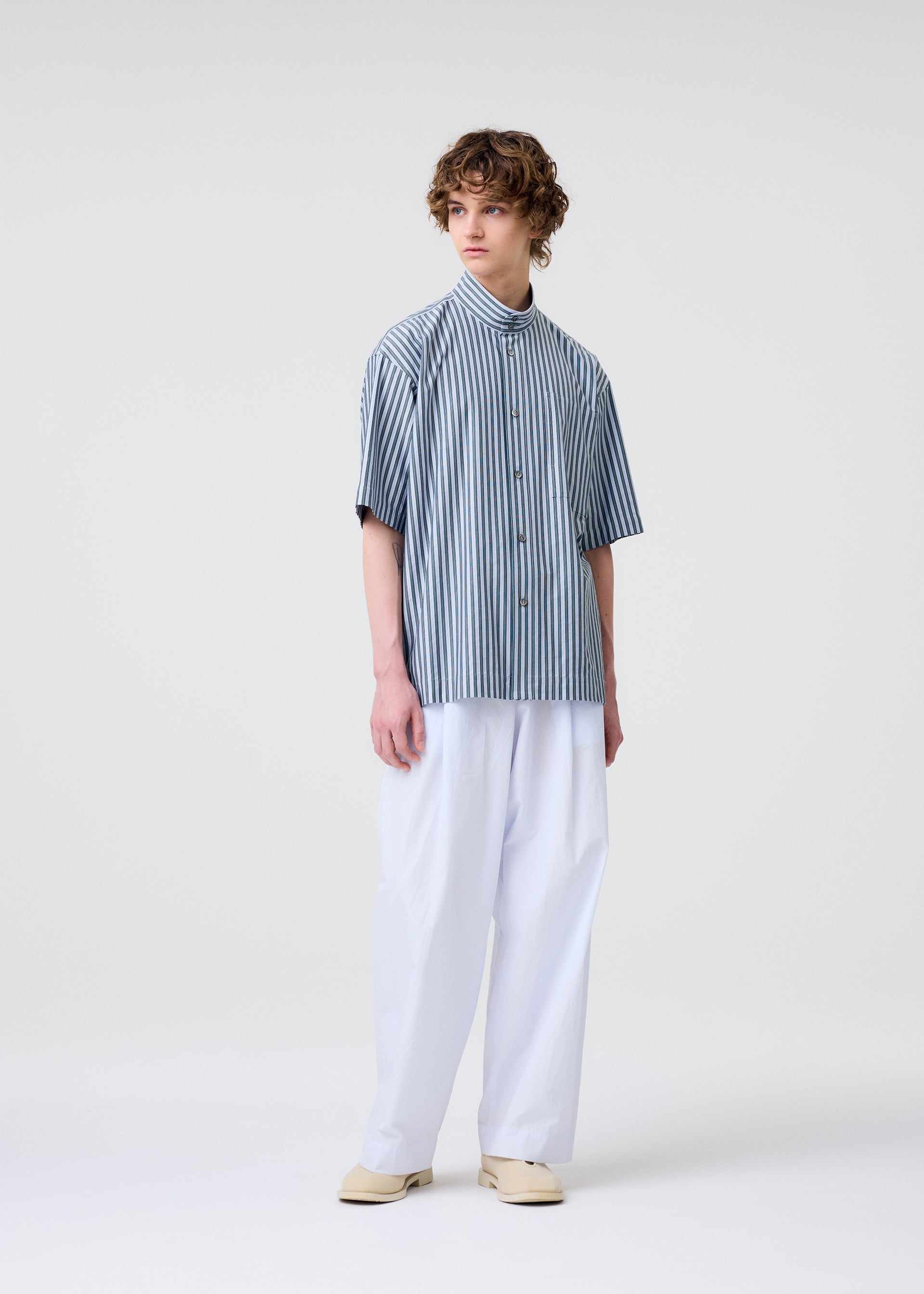A model wears the Homme Plisse Issey Miyake STRIPE JERSEY shirt.