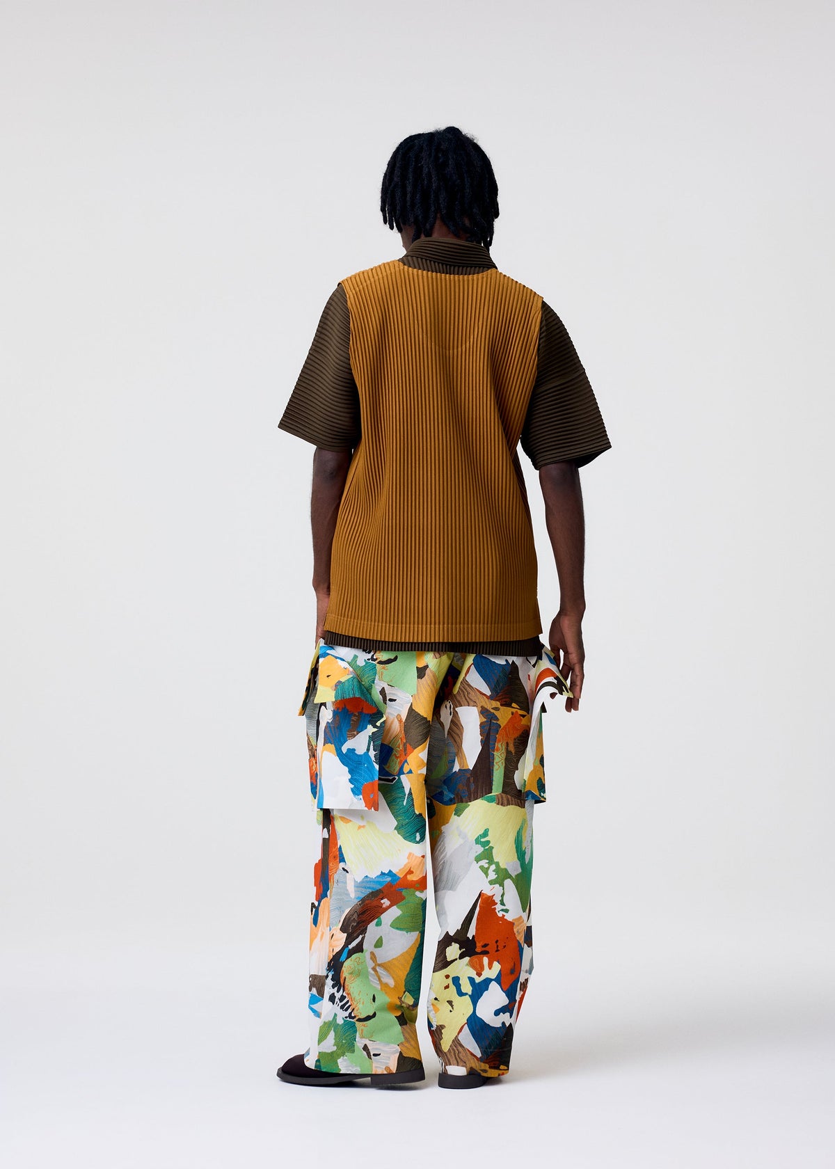A model wears the HOMME PLISSÉ ISSEY MIYAKE MONTHLY COLORS : JUNE monthly-colors-june-t-shirt-genova-metal-ochre.