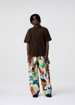 A model wears the HOMME PLISSÉ ISSEY MIYAKE MONTHLY COLORS : JUNE monthly-colors-june-polo-shirt-venice-boat-brown.
