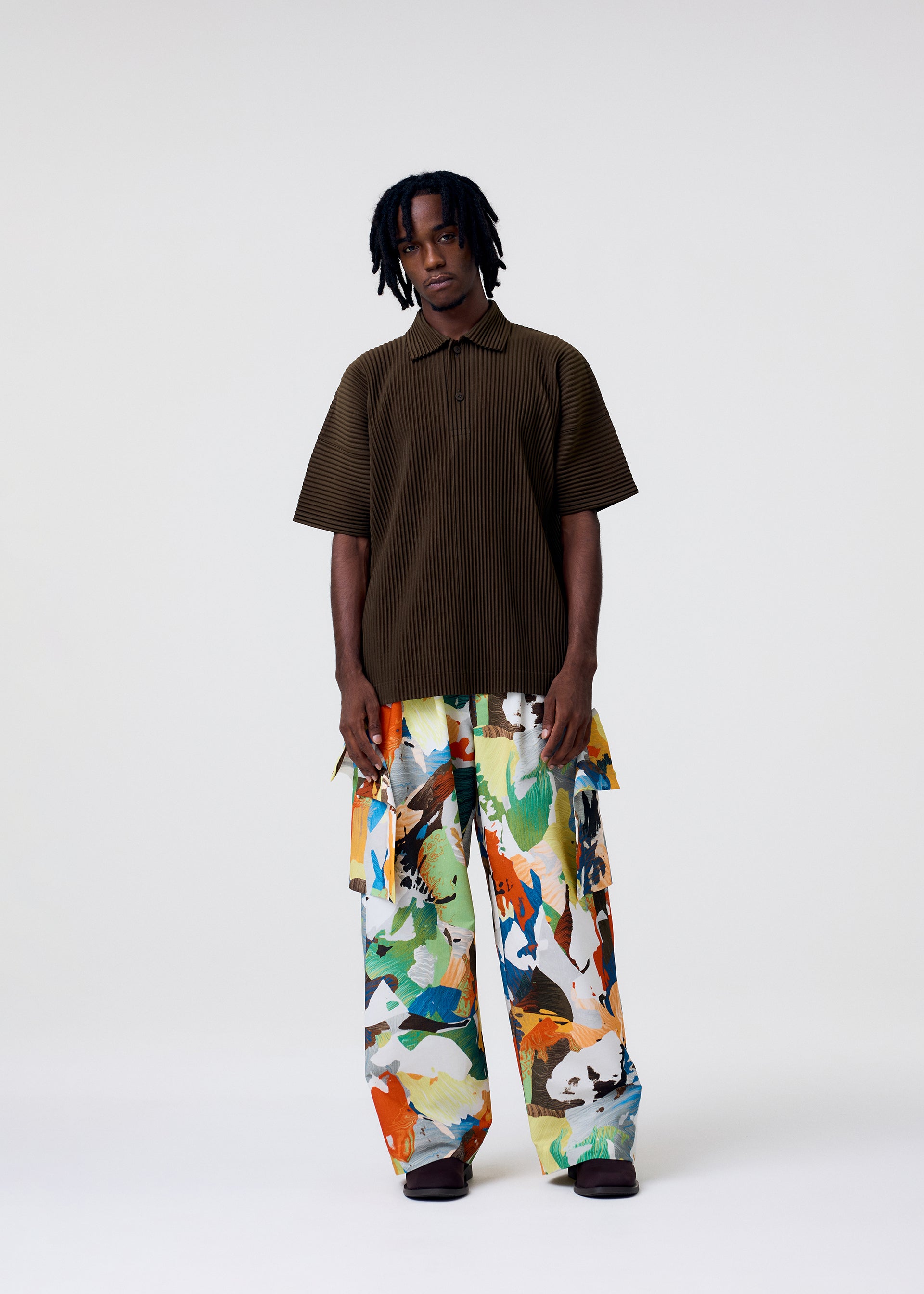 A model wears the HOMME PLISSÉ ISSEY MIYAKE MONTHLY COLORS : JUNE monthly-colors-june-polo-shirt-boboli-moss-ash.