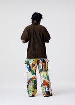 A model wears the HOMME PLISSÉ ISSEY MIYAKE MONTHLY COLORS : JUNE monthly-colors-june-polo-shirt-venice-boat-brown.