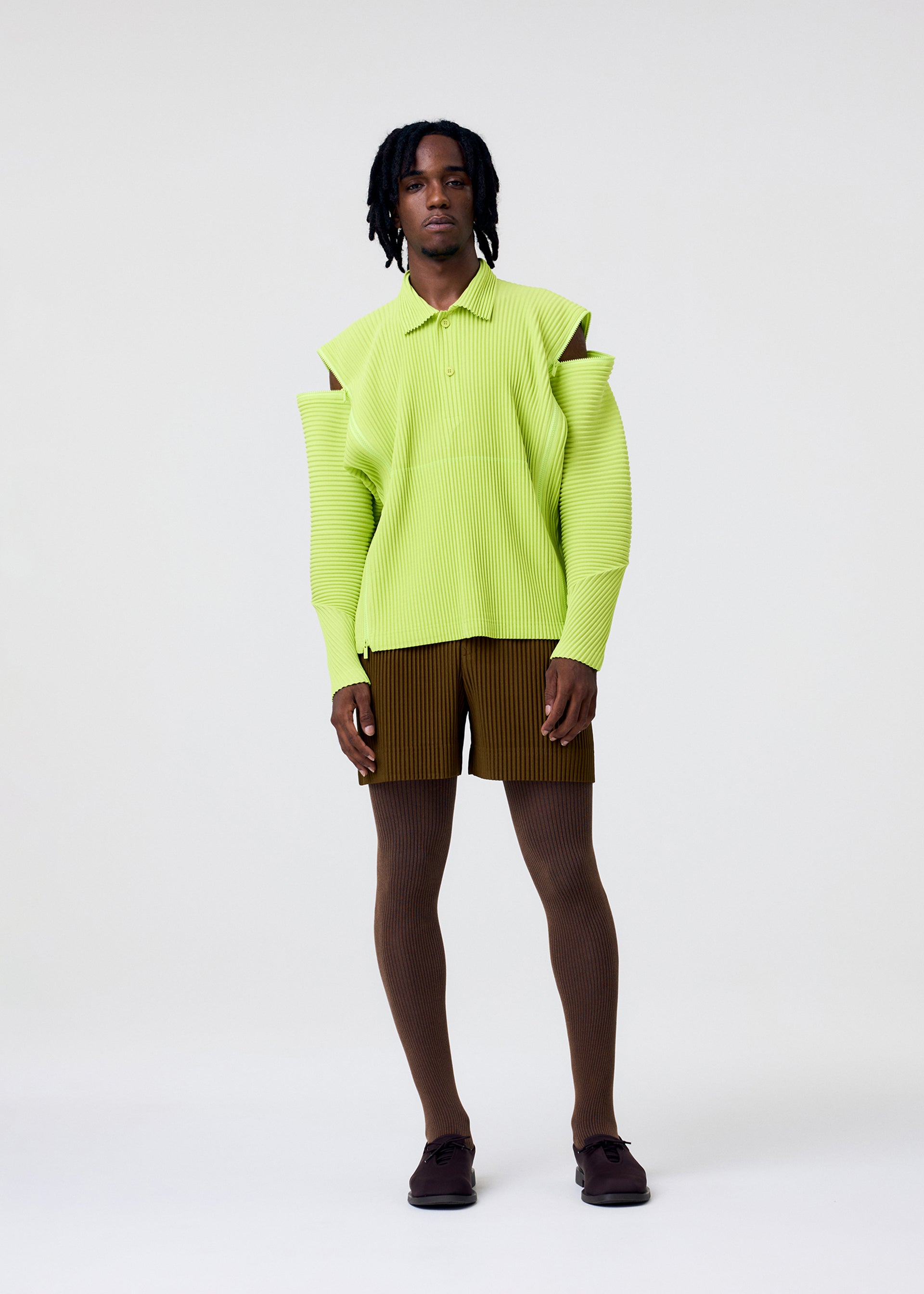 A model wears the HOMME PLISSÉ ISSEY MIYAKE MULTI-FASTENED multi-fastened-polo-shirt-lucca-storico-blue.