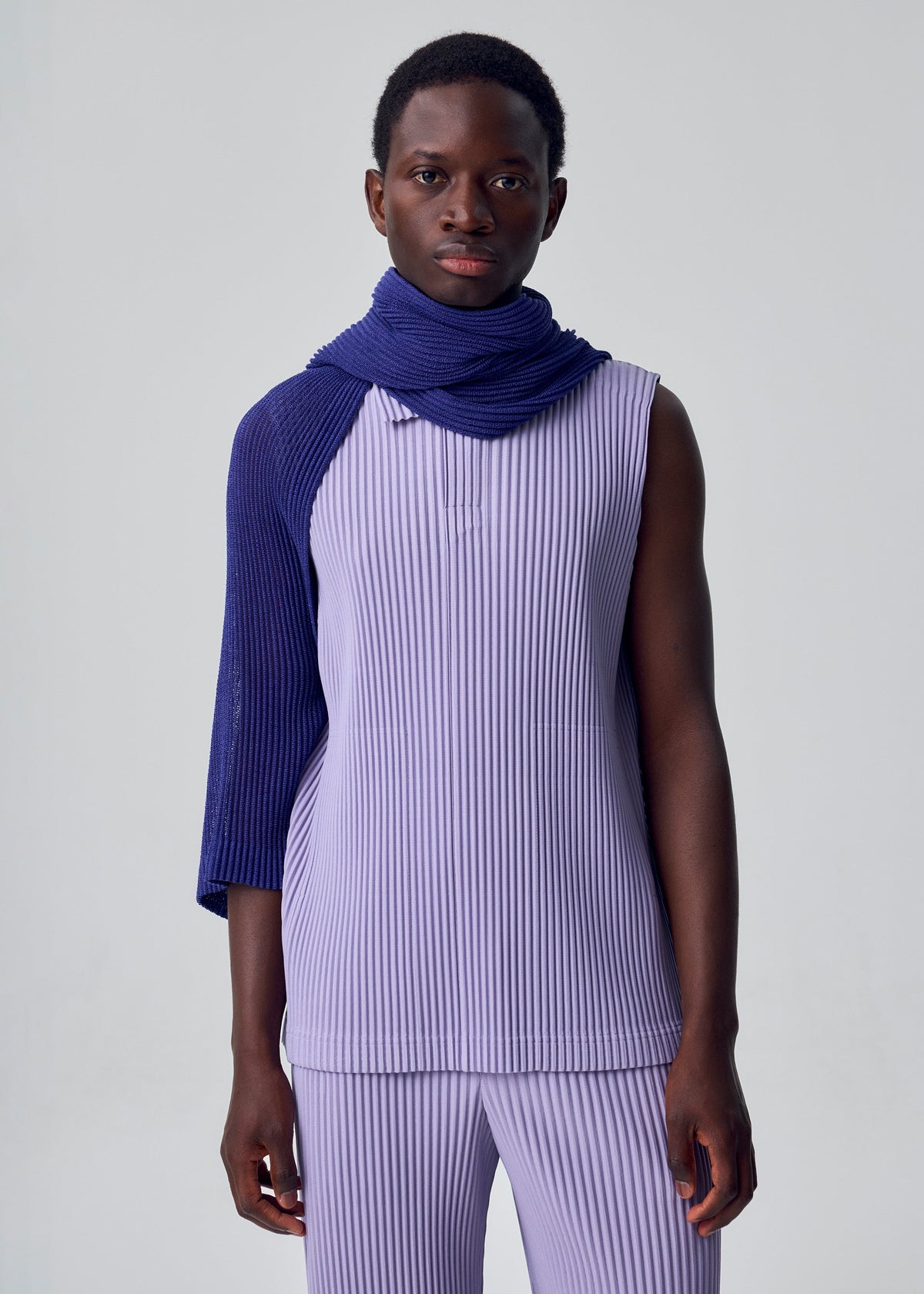 A model wears the HOMME PLISSÉ ISSEY MIYAKE RUSTIC MESH STOLE rustic-mesh-stole-stole-black.