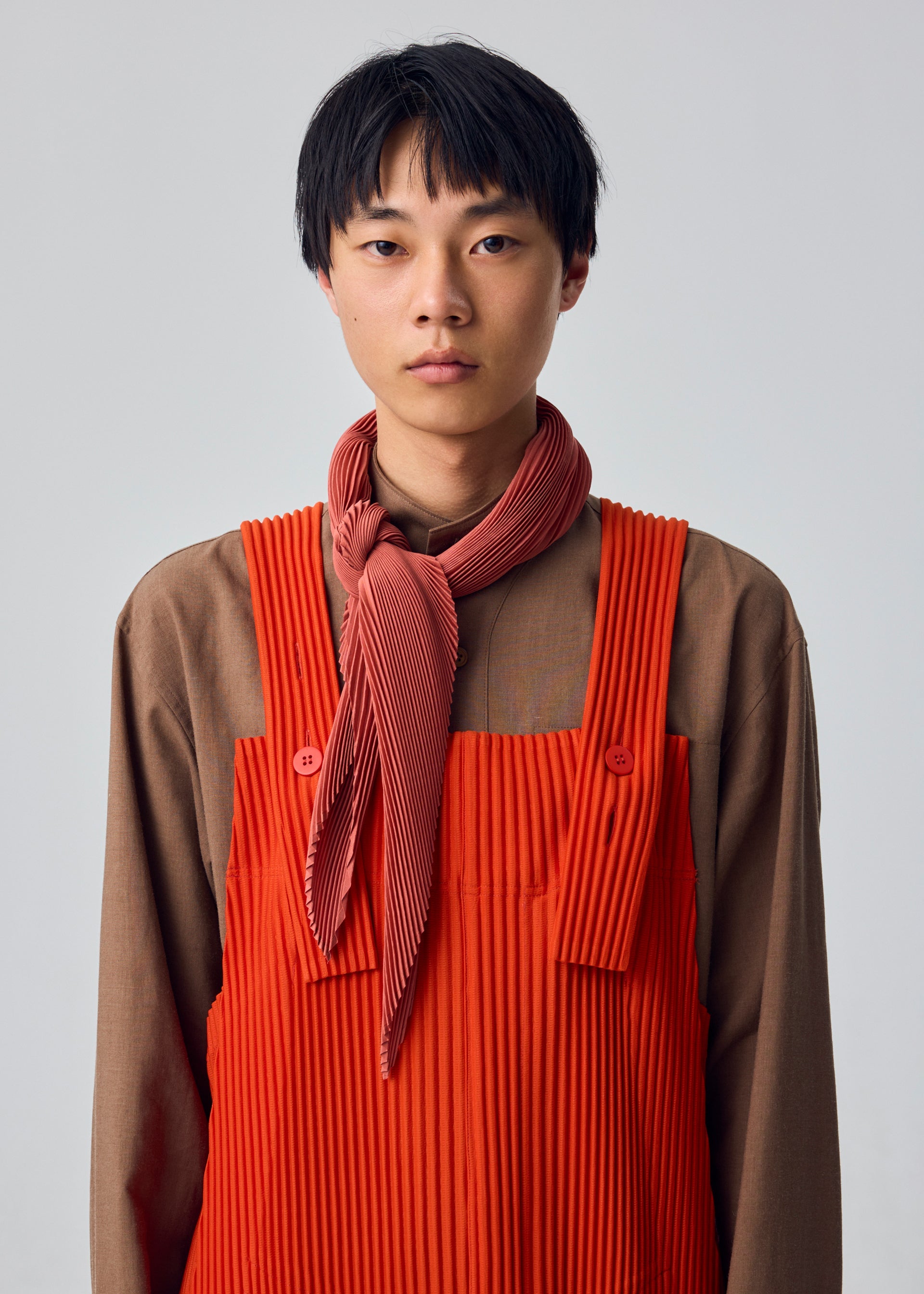 A model wears the HOMME PLISSÉ ISSEY MIYAKE PLEATS STOLE pleats-stole-stole-brown.
