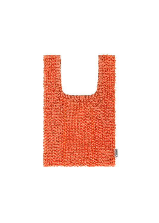 A product shot of the HOMME PLISSÉ ISSEY MIYAKE MESH PLEATS BAG bag in orange.