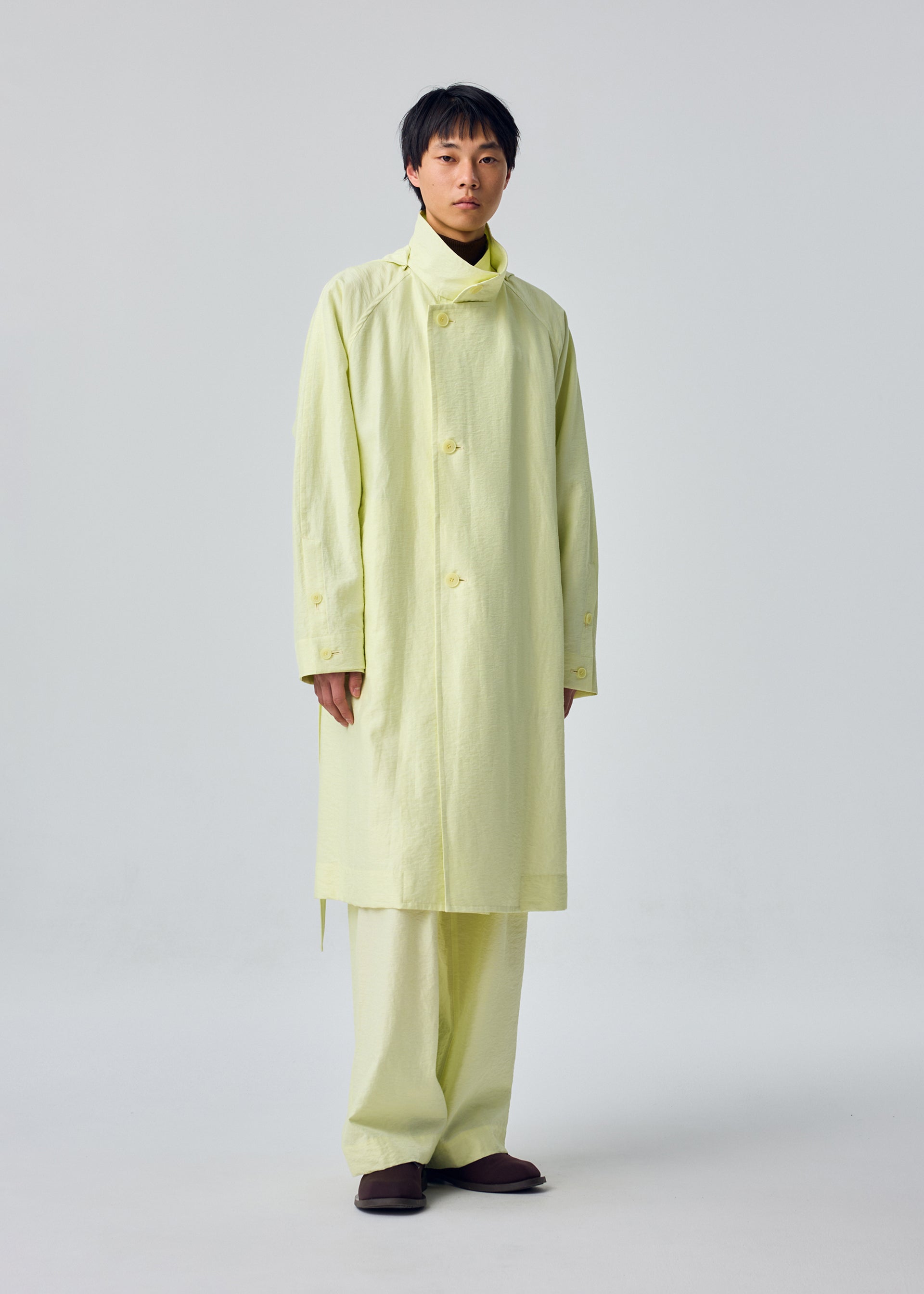 A model wears the HOMME PLISSÉ ISSEY MIYAKE OPACITY coat.