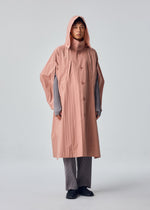 A model wears the HOMME PLISSÉ ISSEY MIYAKE SLIT COAT coat.