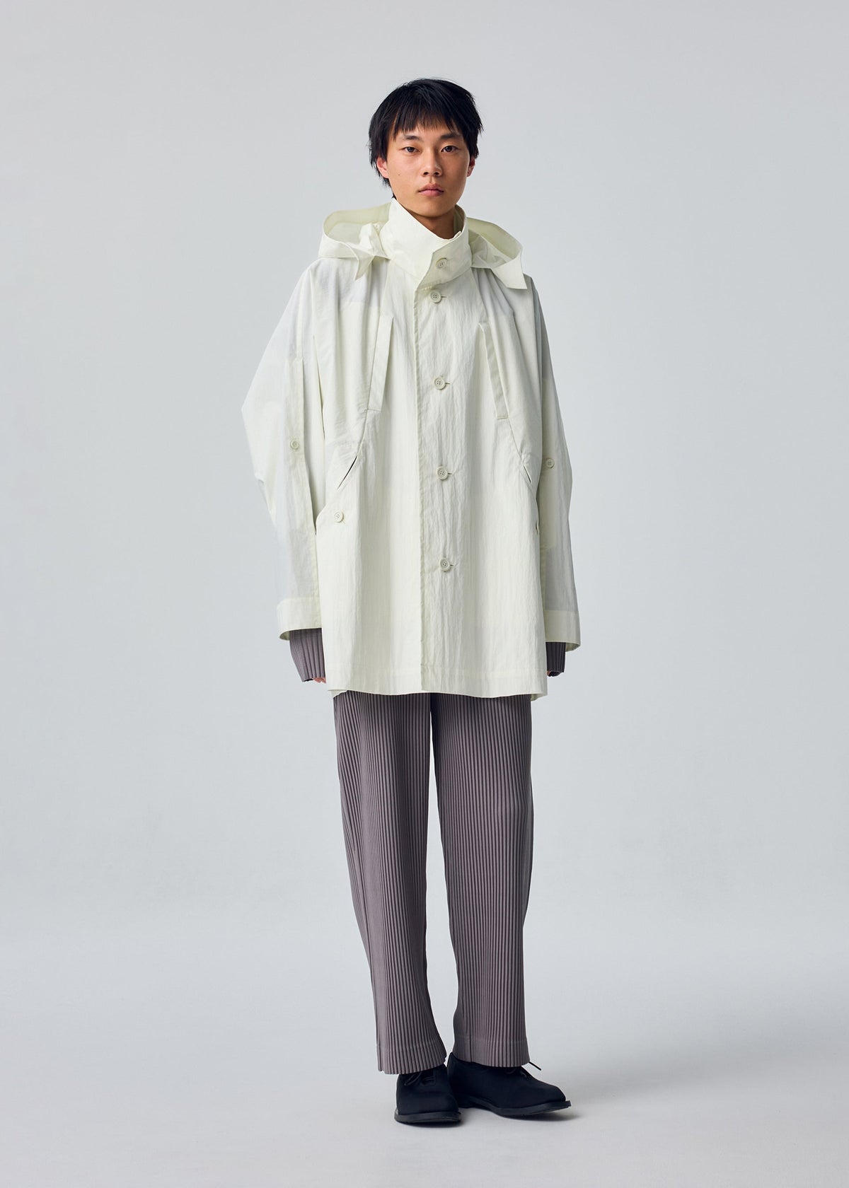 A model wears the HOMME PLISSÉ ISSEY MIYAKE SLIT COAT blouson.