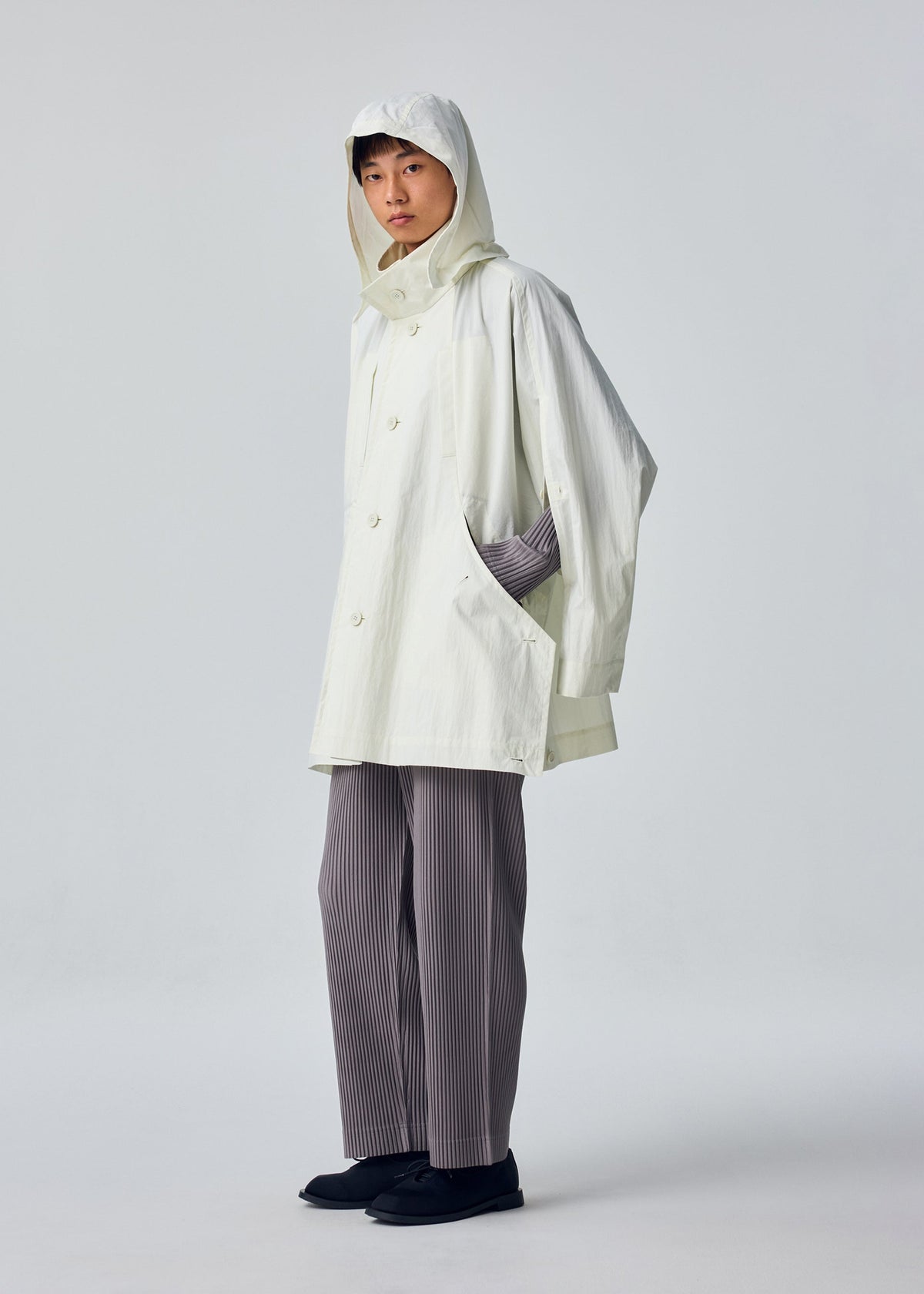 A model wears the HOMME PLISSÉ ISSEY MIYAKE SLIT COAT blouson.