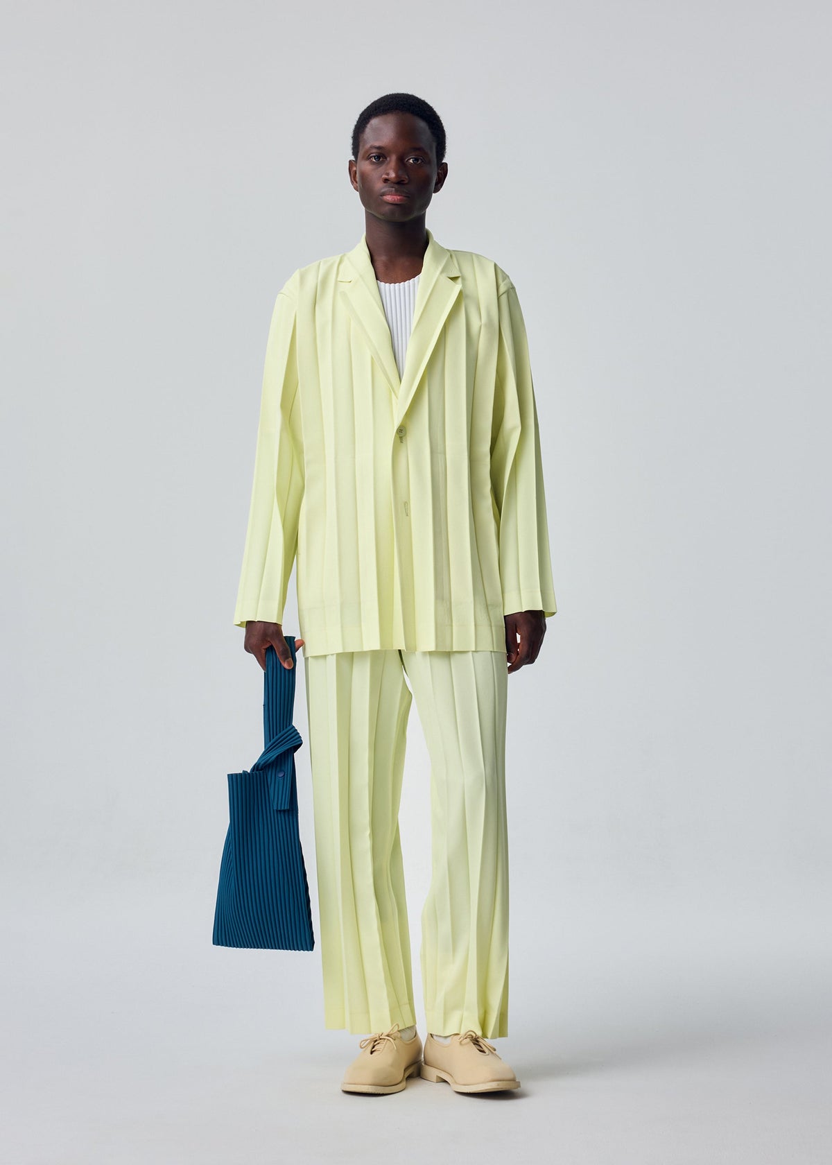 A model wears the HOMME PLISSÉ ISSEY MIYAKE EDGE ENSEMBLE jacket.