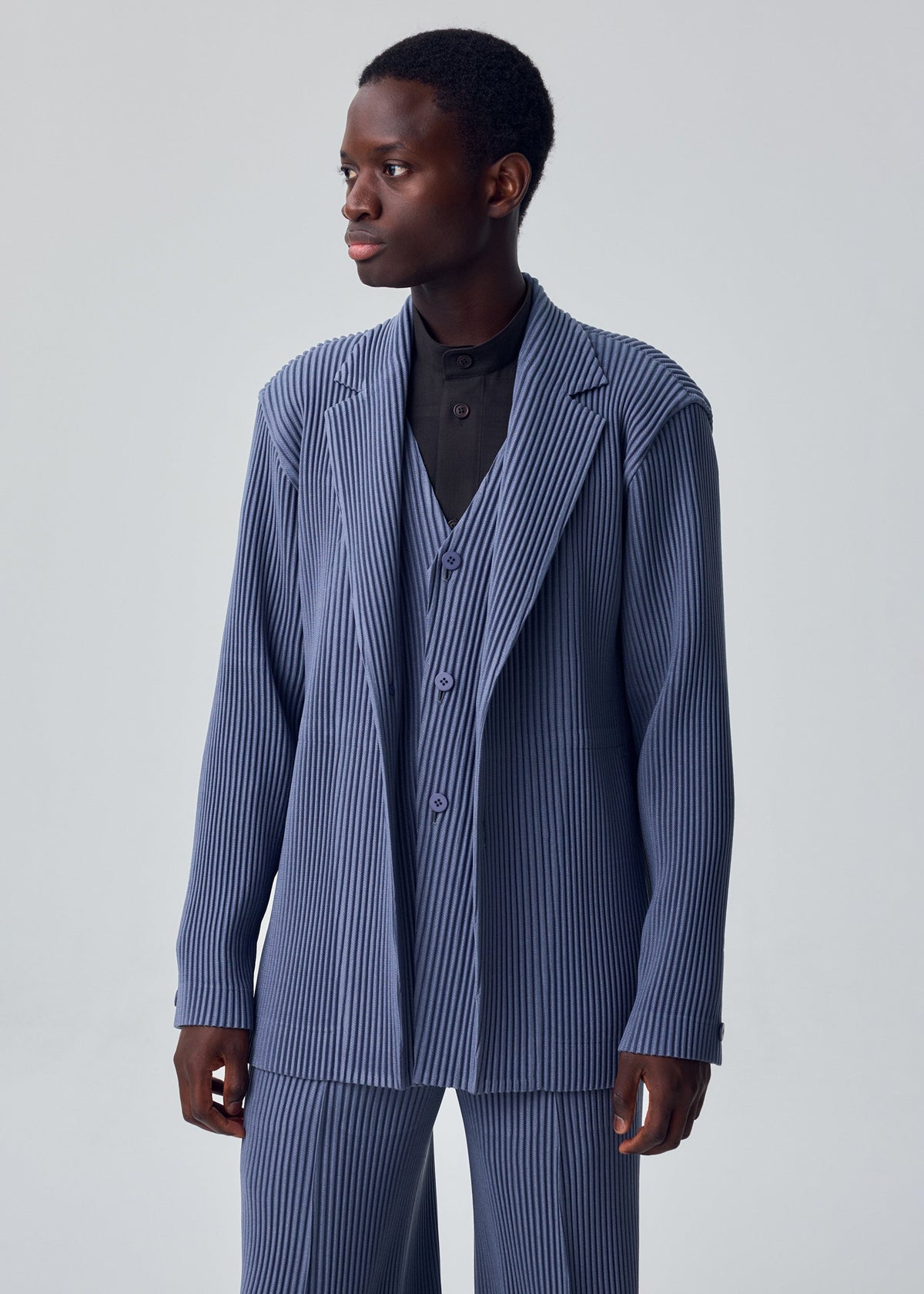 A model wears the HOMME PLISSÉ ISSEY MIYAKE KERSEY PLEATS jacket.