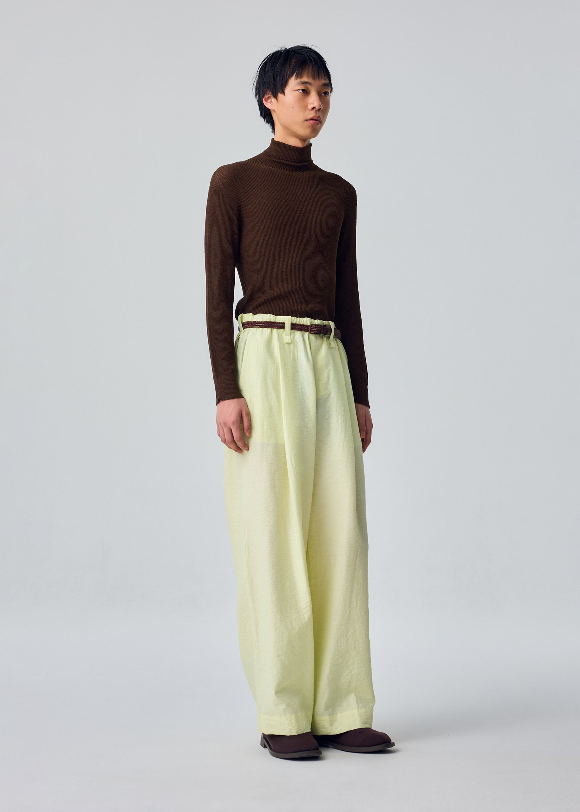 A model wears the HOMME PLISSÉ ISSEY MIYAKE OPACITY trousers.