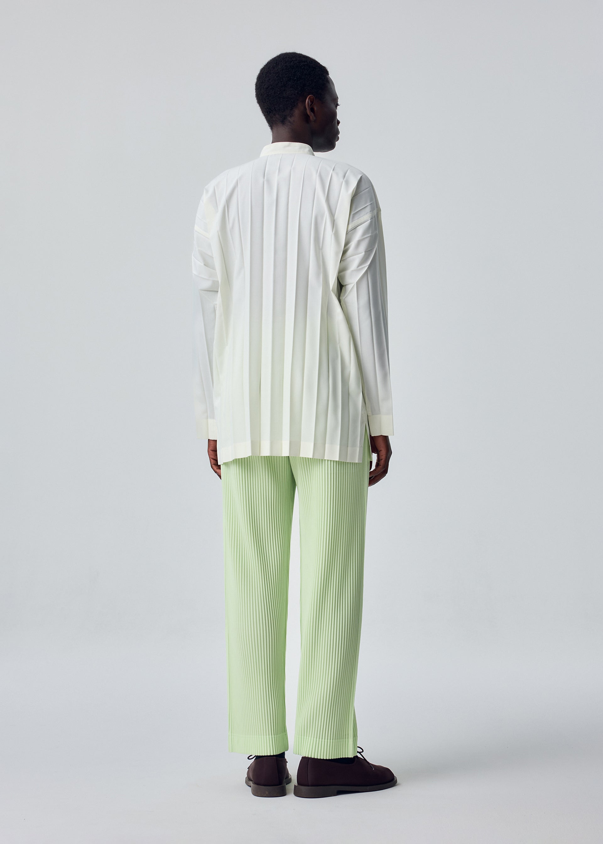 A model wears the HOMME PLISSÉ ISSEY MIYAKE EDGE SHIRT edge-shirt-shirt-white-2-fw26.