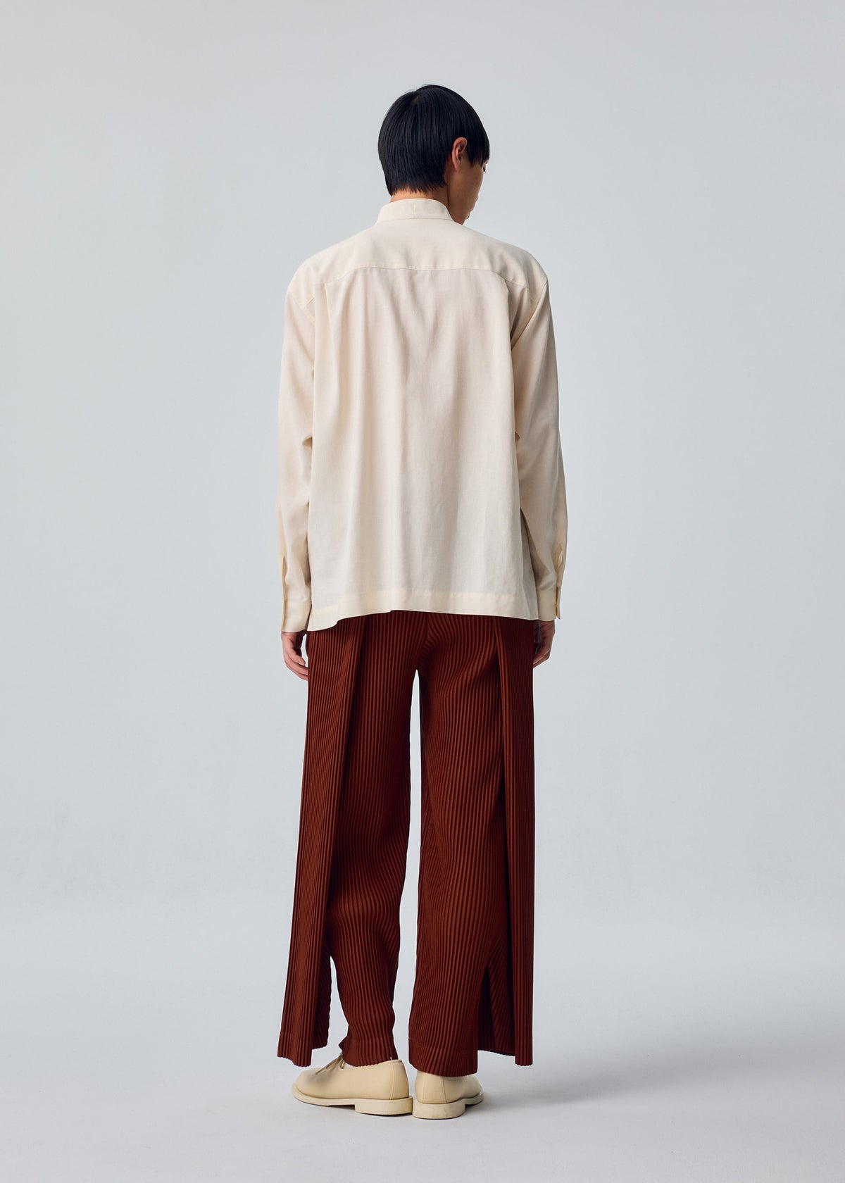 A model wears the HOMME PLISSÉ ISSEY MIYAKE PL RAMIE SHIRT pl-ramie-shirt-shirt-brown-4.