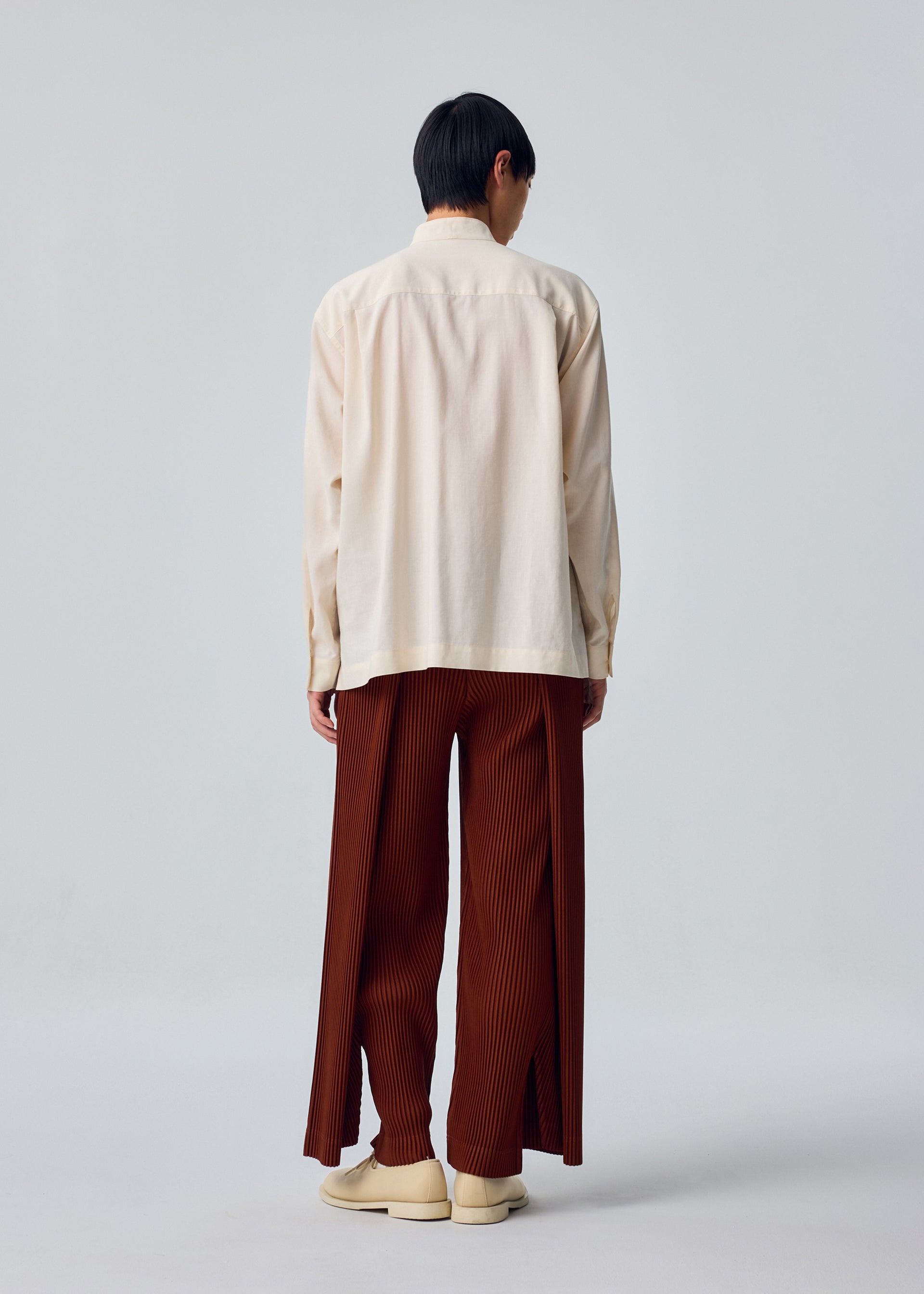 A model wears the HOMME PLISSÉ ISSEY MIYAKE PL RAMIE SHIRT pl-ramie-shirt-shirt-brown-4.