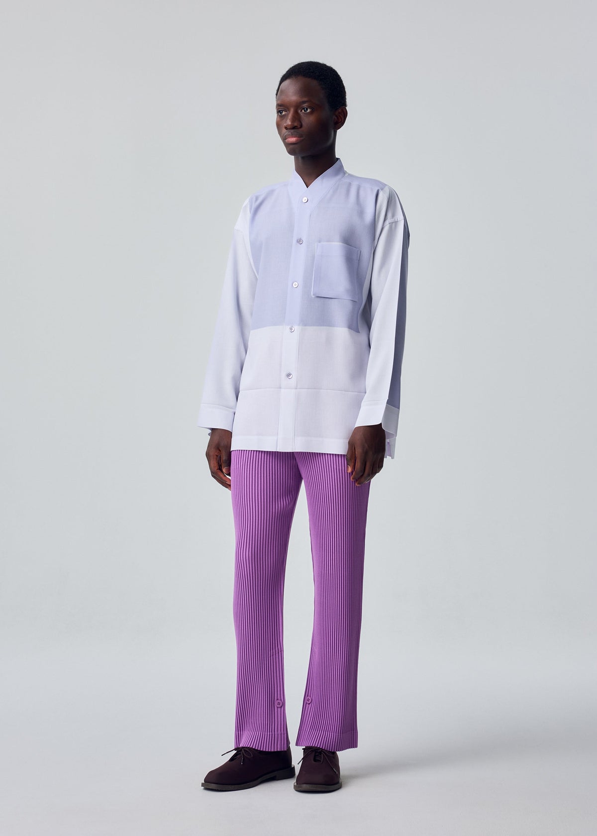 A model wears the HOMME PLISSÉ ISSEY MIYAKE PRESS SHIRT shirt.