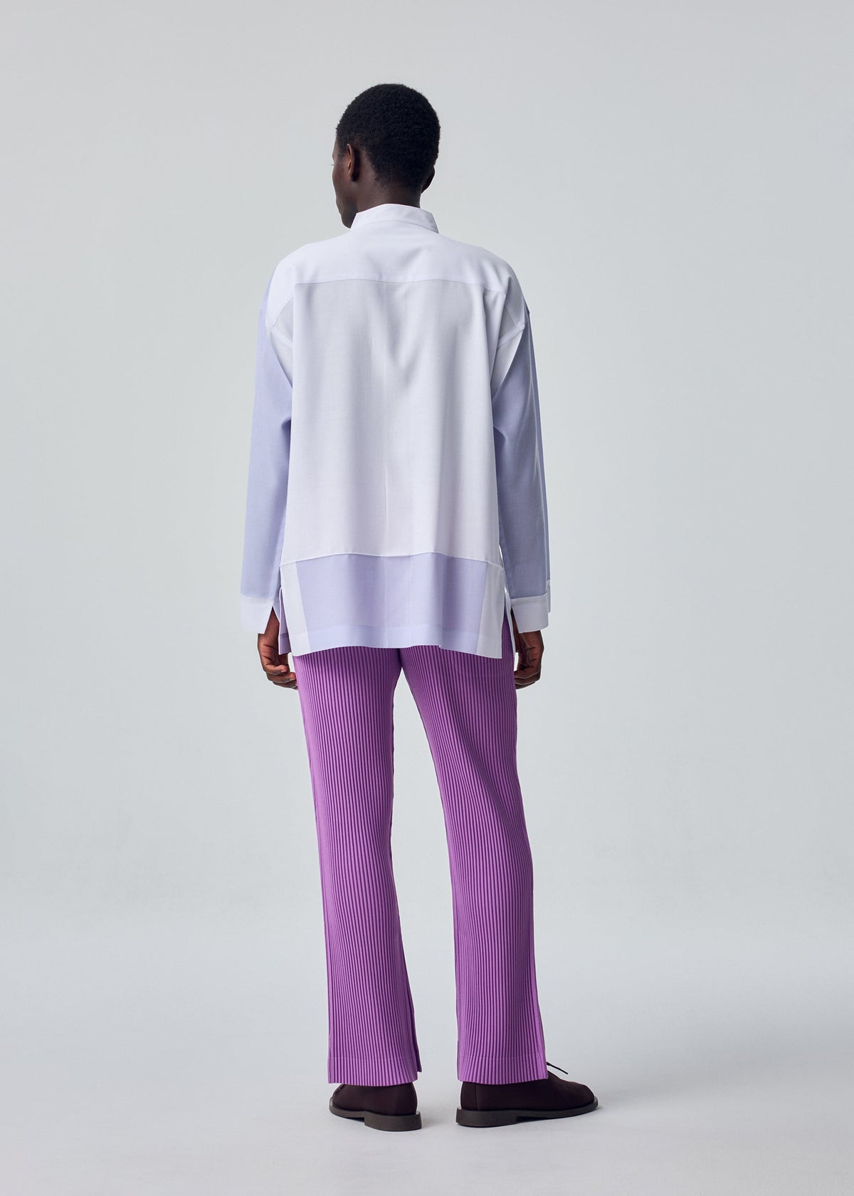 A model wears the HOMME PLISSÉ ISSEY MIYAKE PRESS SHIRT shirt.