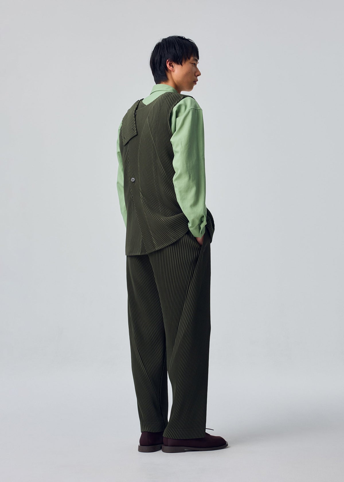A model wears the HOMME PLISSÉ ISSEY MIYAKE SLASH vest.