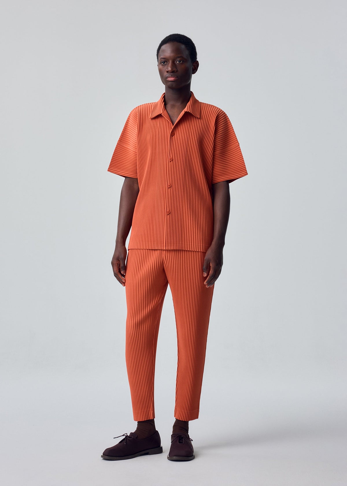 A model wears the HOMME PLISSÉ ISSEY MIYAKE MONTHLY COLORS : AUGUST monthly-colors-august-trousers-black-4.