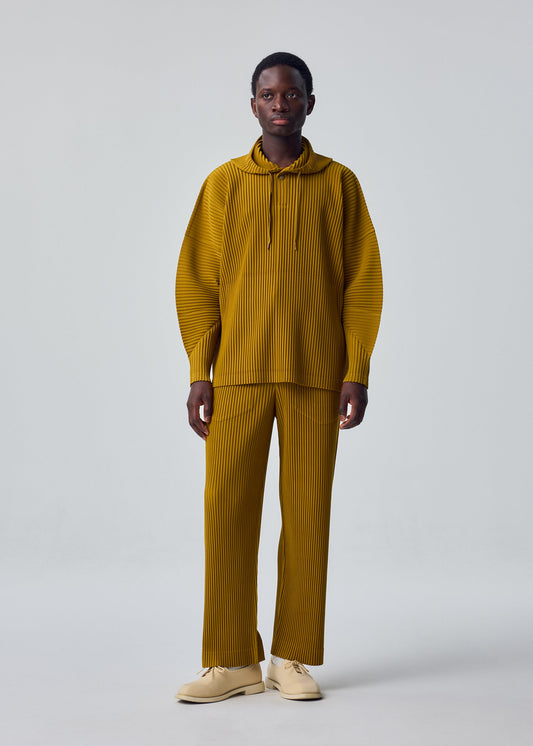 A model wears the HOMME PLISSÉ ISSEY MIYAKE MONTHLY COLORS : OCTOBER trousers.