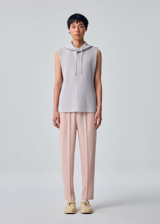 A model wears the HOMME PLISSÉ ISSEY MIYAKE COMPLEAT TROUSERS trousers.