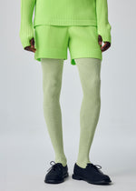A model wears the HOMME PLISSÉ ISSEY MIYAKE COLOR PLEATS 1 color-pleats-1-shorts-ray-yellow.